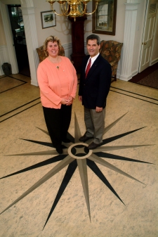Photograph of a a man and a lady standing on a floor with a star